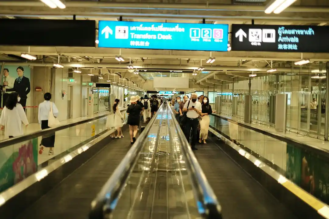 空港の到着エリアにある動く歩道を利用する人々