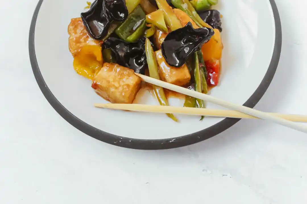 一盤色彩鮮豔的家常炒豆腐,裡面有豆腐塊、紅蘿蔔、青椒等蔬菜。