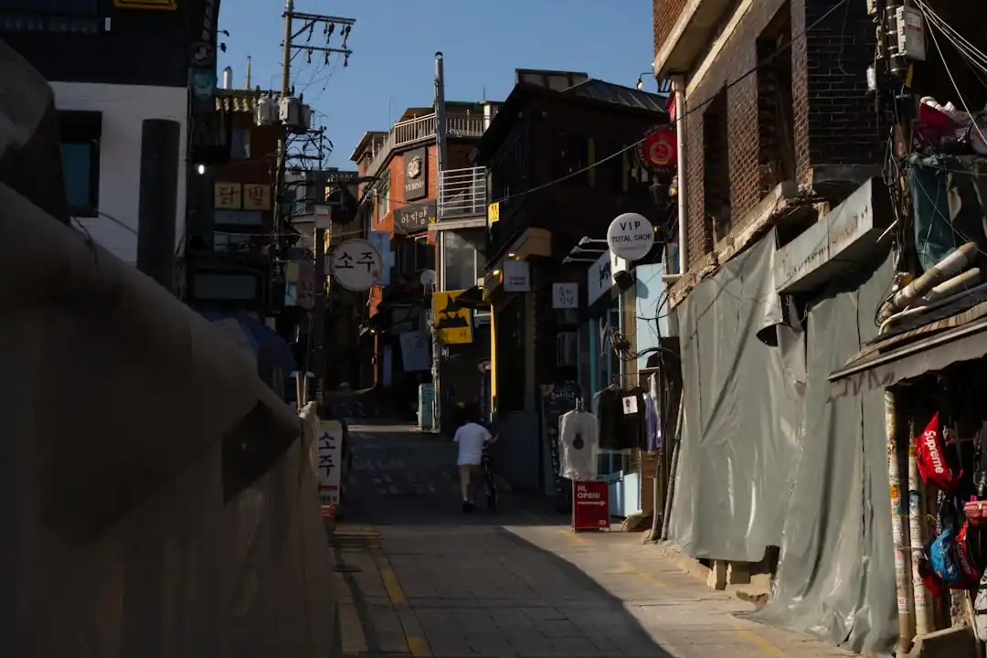 한 사람이 서울의 좁은 골목길을 걸어가고 있다.