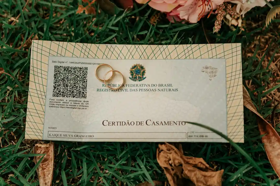 芝生の上に置かれた結婚証明書と結婚指輪、そして花束