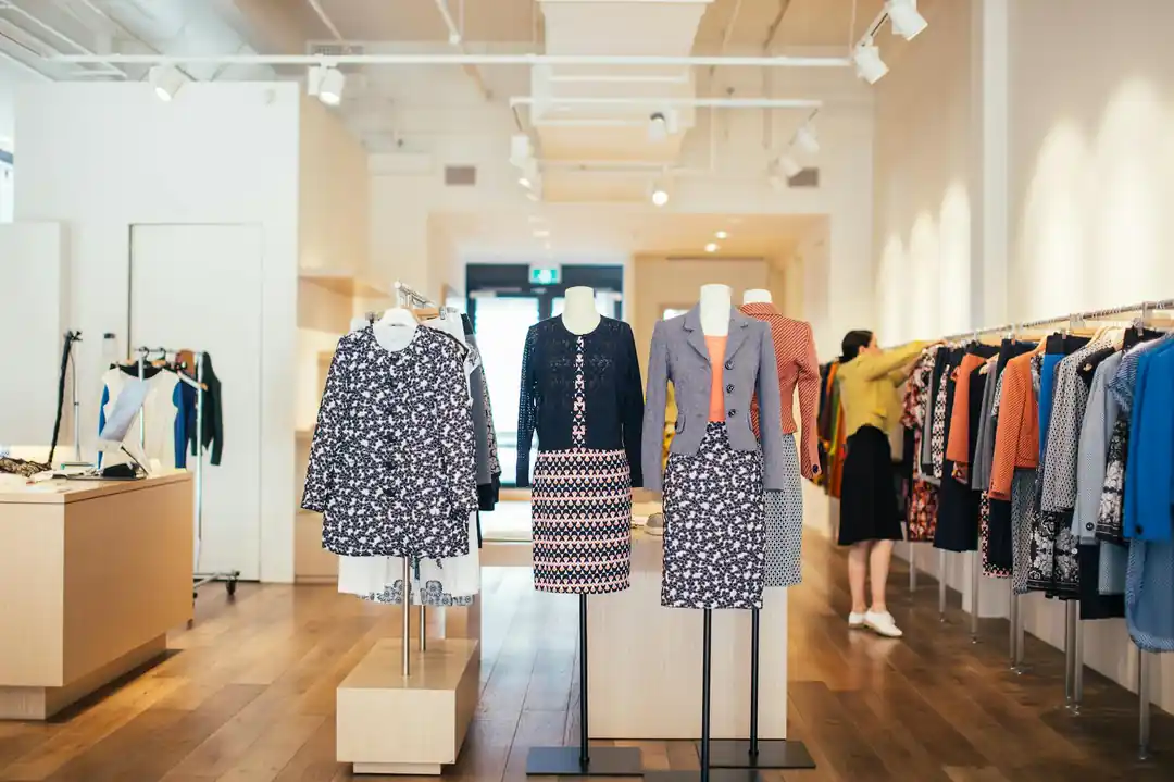マネキンとラックにカラフルでトレンディな婦人服が並ぶ、スタイリッシュなブティック