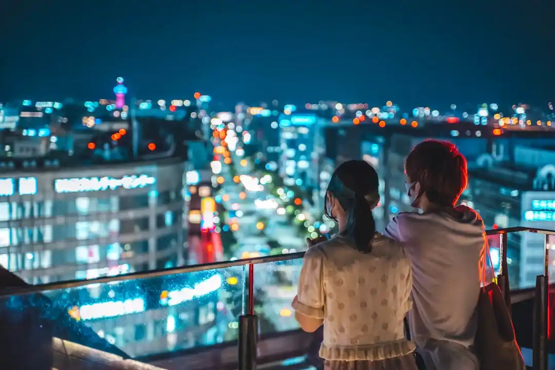 夜の博多駅の屋上から街を眺めるカップル