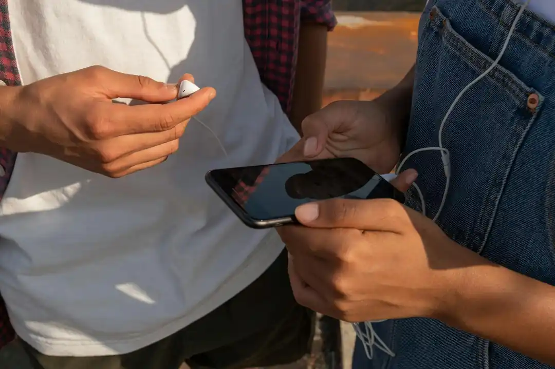 スマートフォンで音楽を共有する10代の若者たち