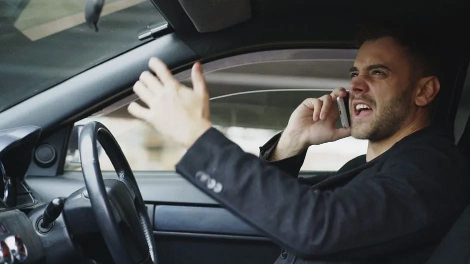 車内で電話をしながらストレスを感じ、身振り手振りで不満をあらわにする男性