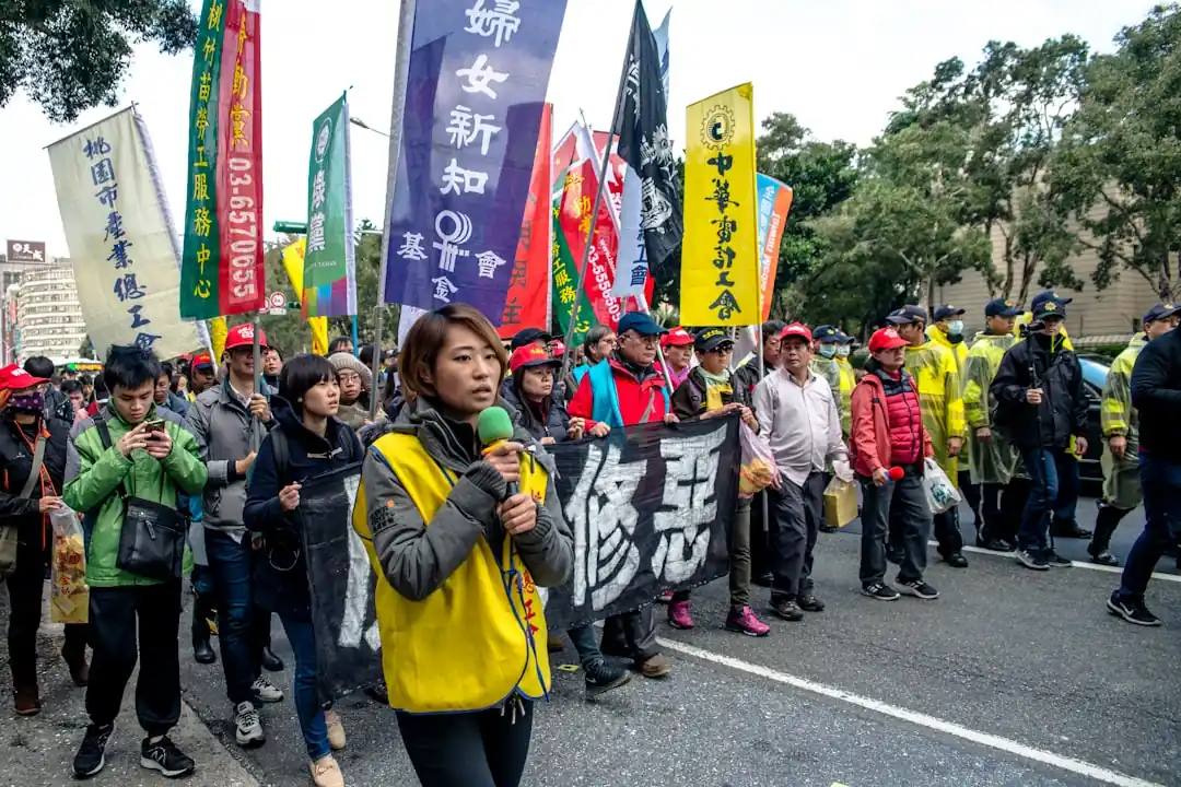 大甲媽祖遶境的隊伍,旗幟飛揚,信徒們跟隨著神轎,充滿了虔誠與活力。