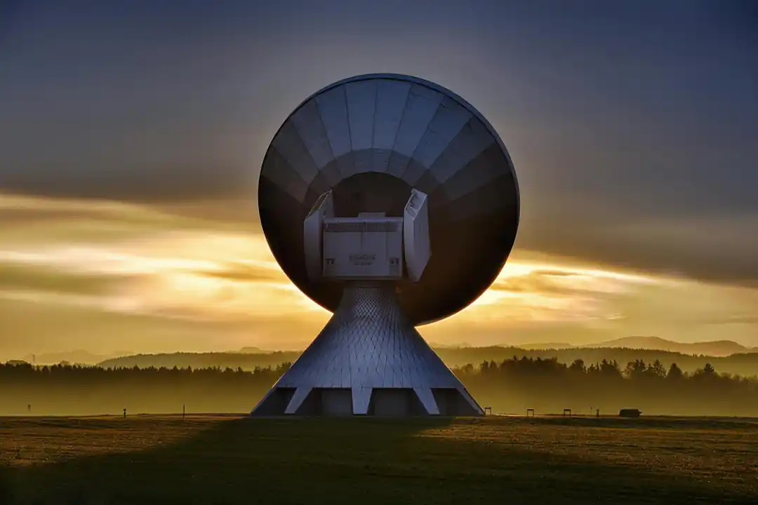 一座大型衛星地面接收站的剪影在多彩的夕陽下。