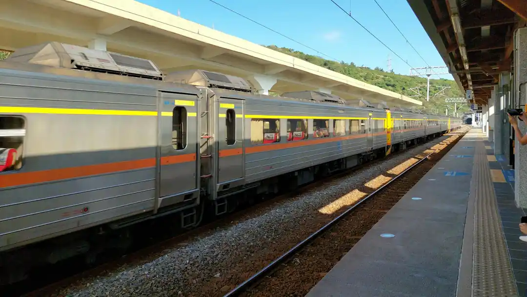 一列高鐵列車停在戶外月台,背景是藍天白雲,象徵著台灣的旅行。