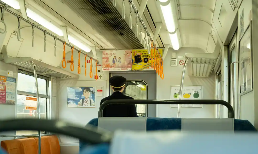 日本の電車内で、前方を指差す車掌