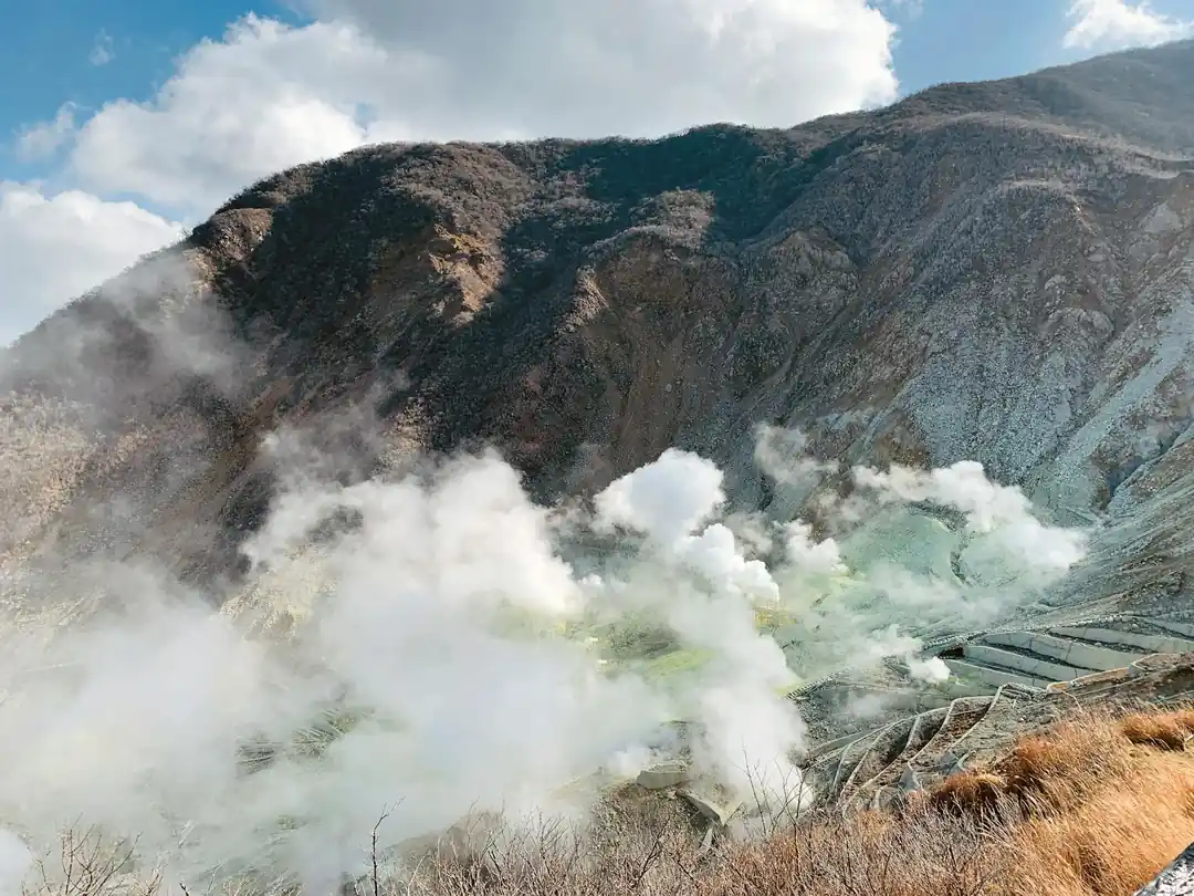 荒々しい岩の谷から煙が立ち上る活火山の風景