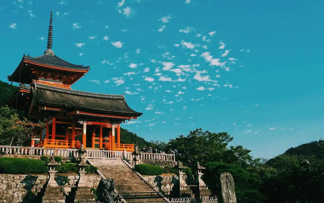 青空の下に佇む清水寺の本堂と三重塔。日本の伝統的な木造建築の美しさが際立っている。