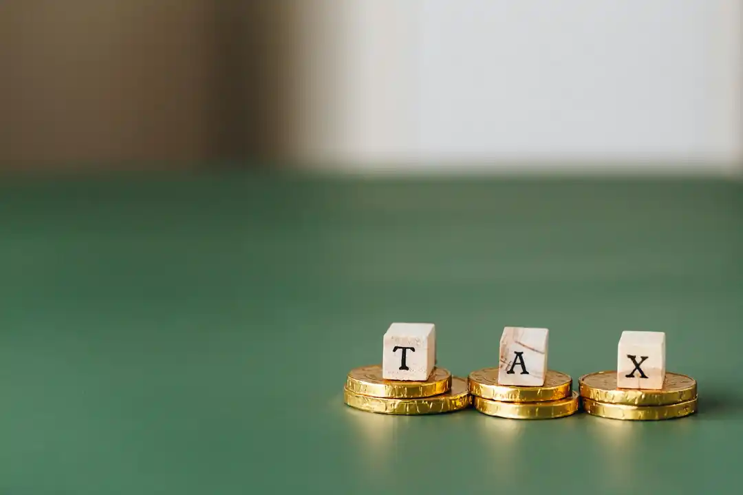 木塊堆疊成的TAX字樣與錢幣