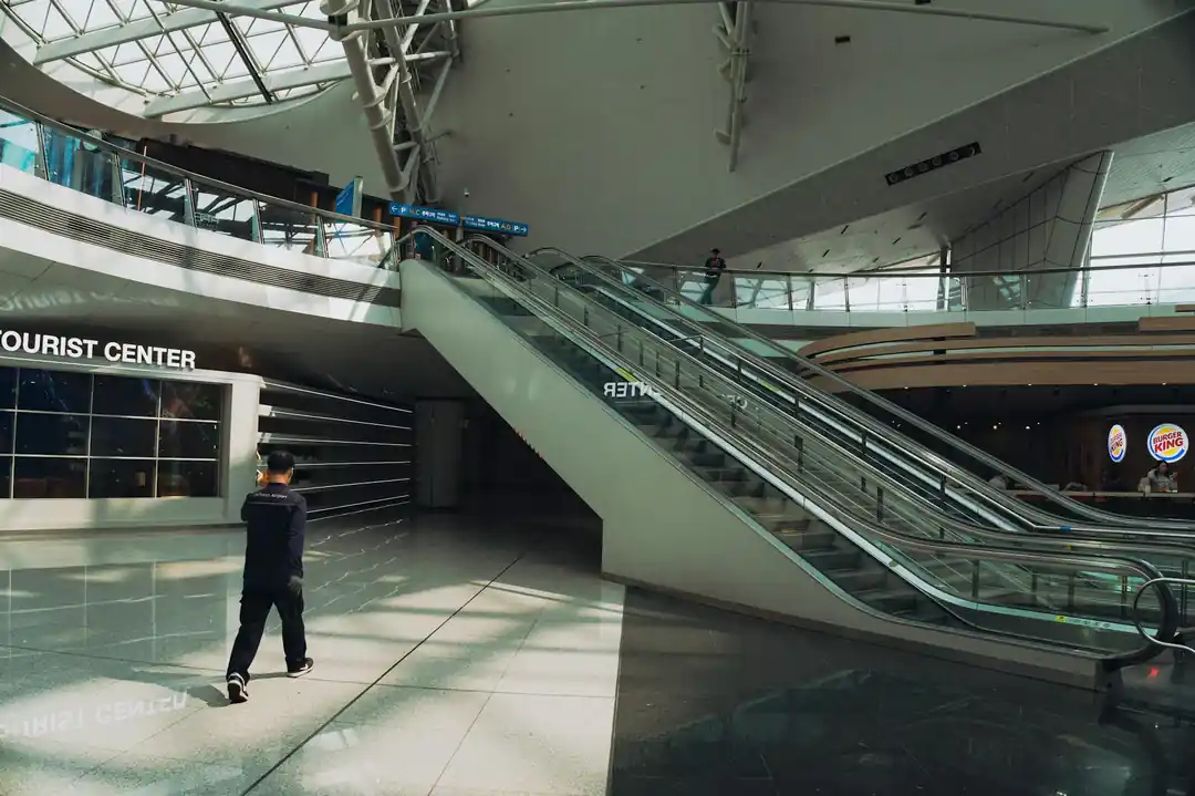 仁川国際空港の広々としたターミナル内部。エスカレーターと案内所が見える。