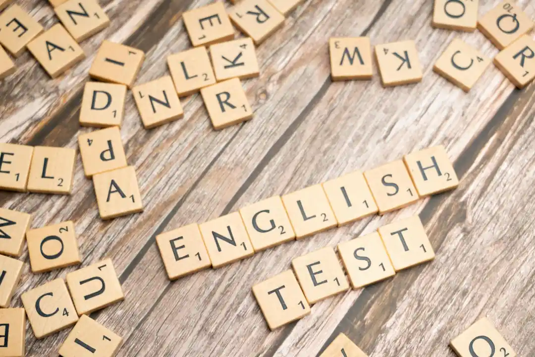 나무 배경 위에 'English Test'라는 단어를 만들고 있는 스크래블 타일