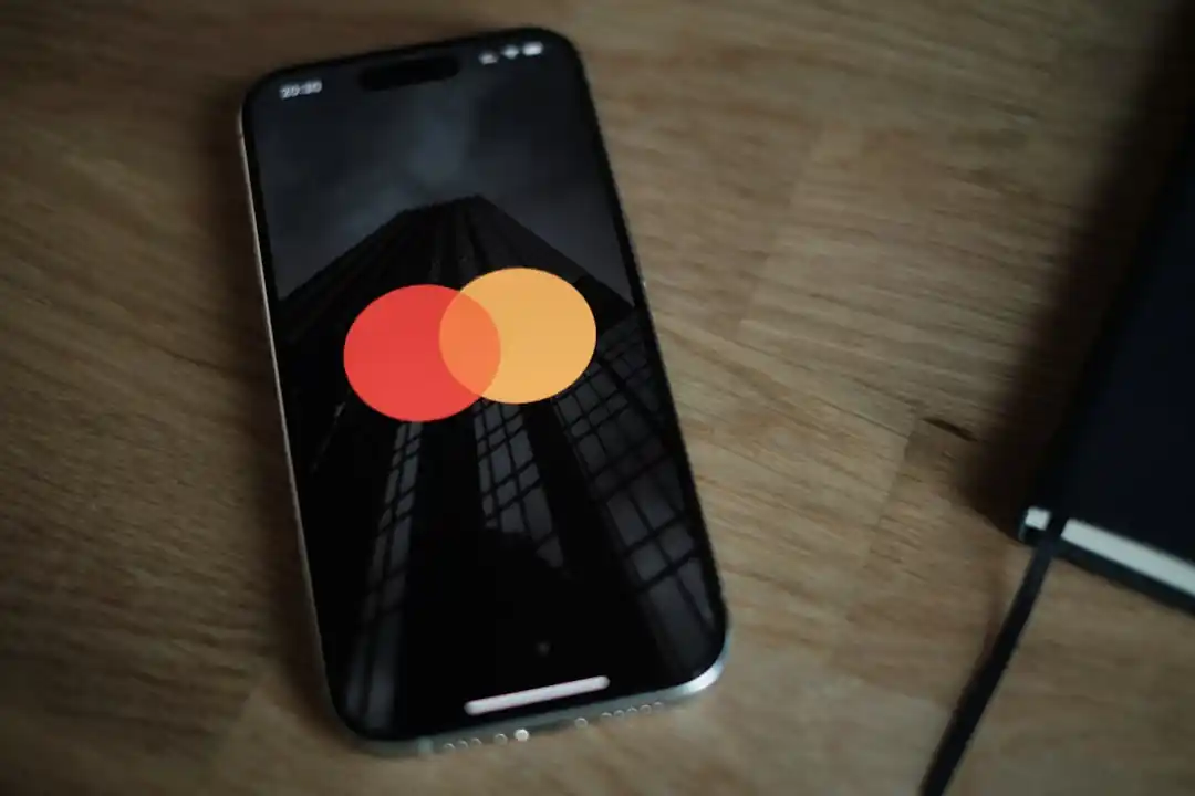 一支智慧型手機的螢幕上顯示著銀行App的介面,背景是溫暖的木質桌面,象徵著數位金融的便利與日常。