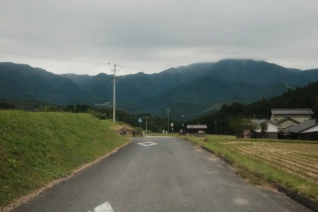 霧がかった山々へと続く、田舎の一本道。