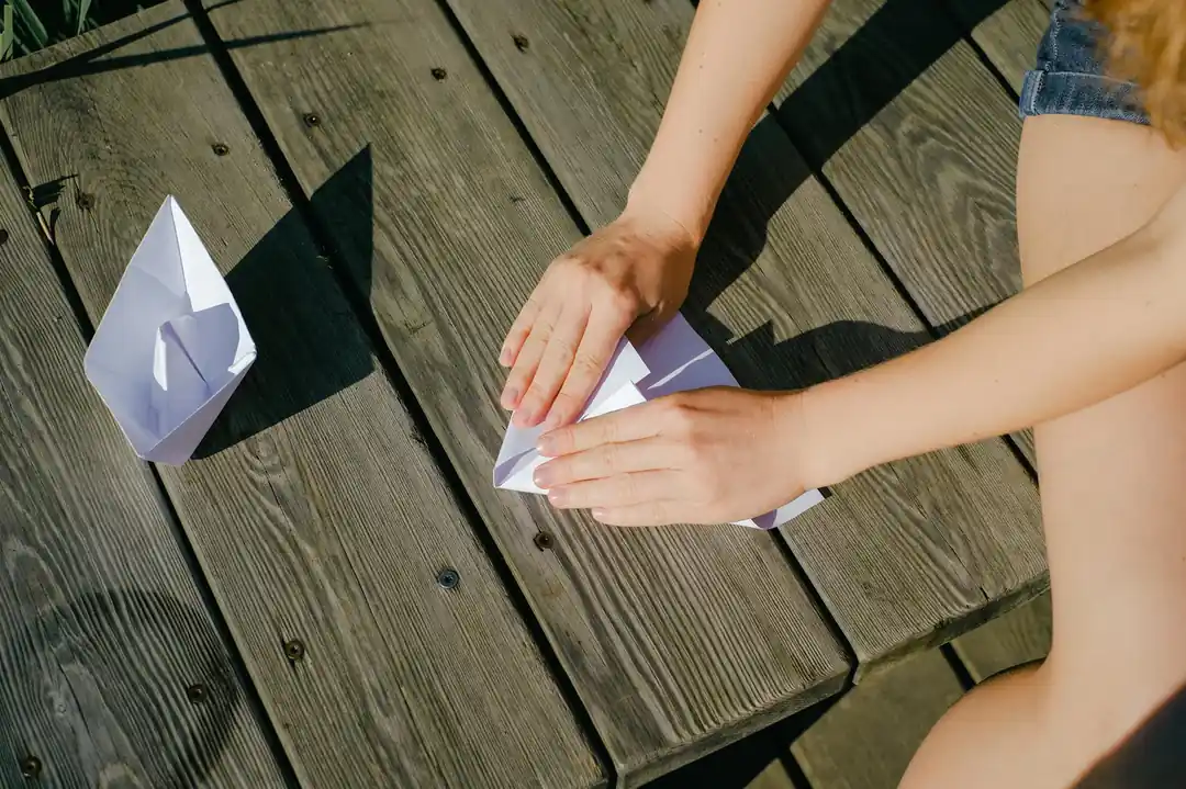 一雙手正在摺紙。