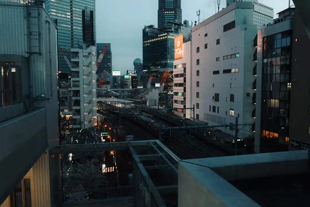 夕暮れ時の高田馬場の街並み。電車とビル群の灯りが温かい。