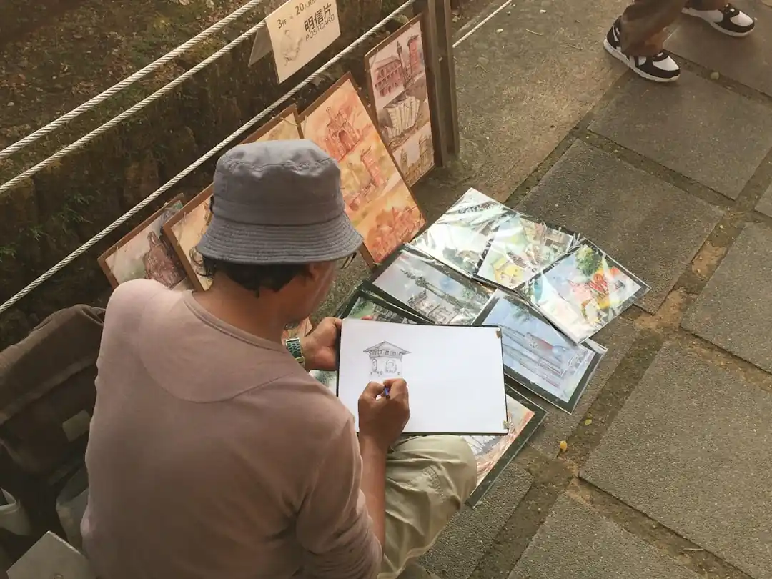 한 남자가 벤치에 앉아 지도를 보고 있다.