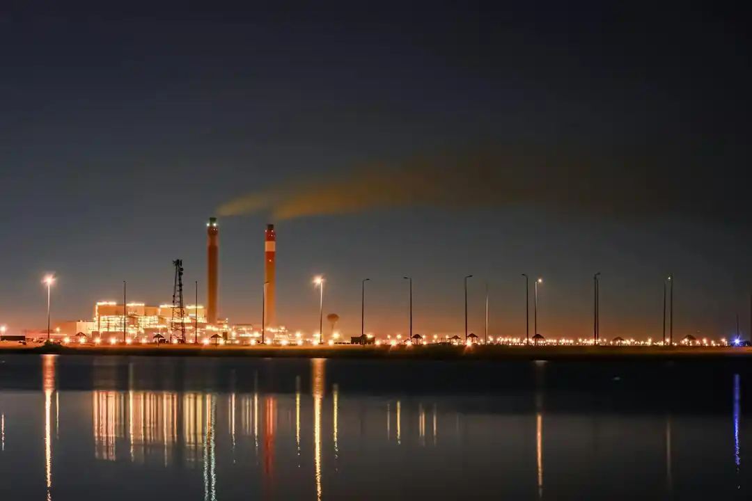夜の水面に工場の明かりが鮮やかに反射している幻想的な風景