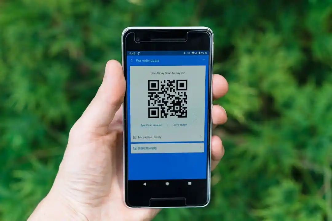 一支智慧型手機的螢幕上顯示著行動支付的QR Code。