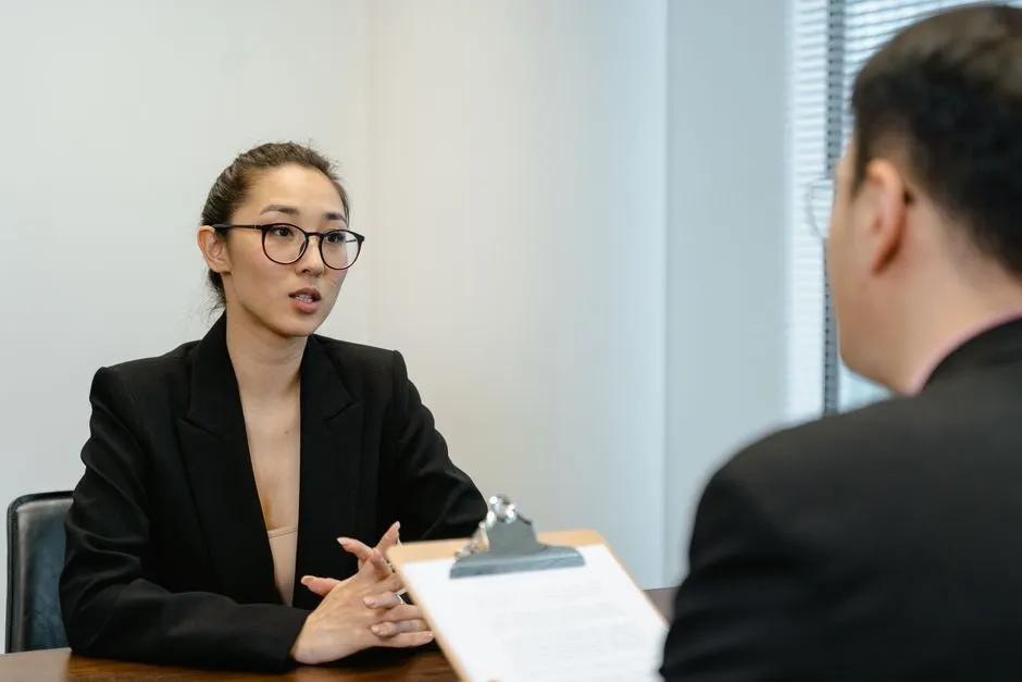 사무실 환경에서 비즈니스 정장을 입고 진지하게 면접에 임하고 있는 모습
