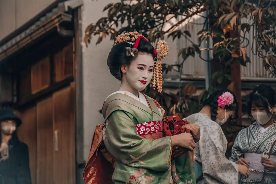 日本の伝統的な家屋の前でポーズをとる着物姿の女性