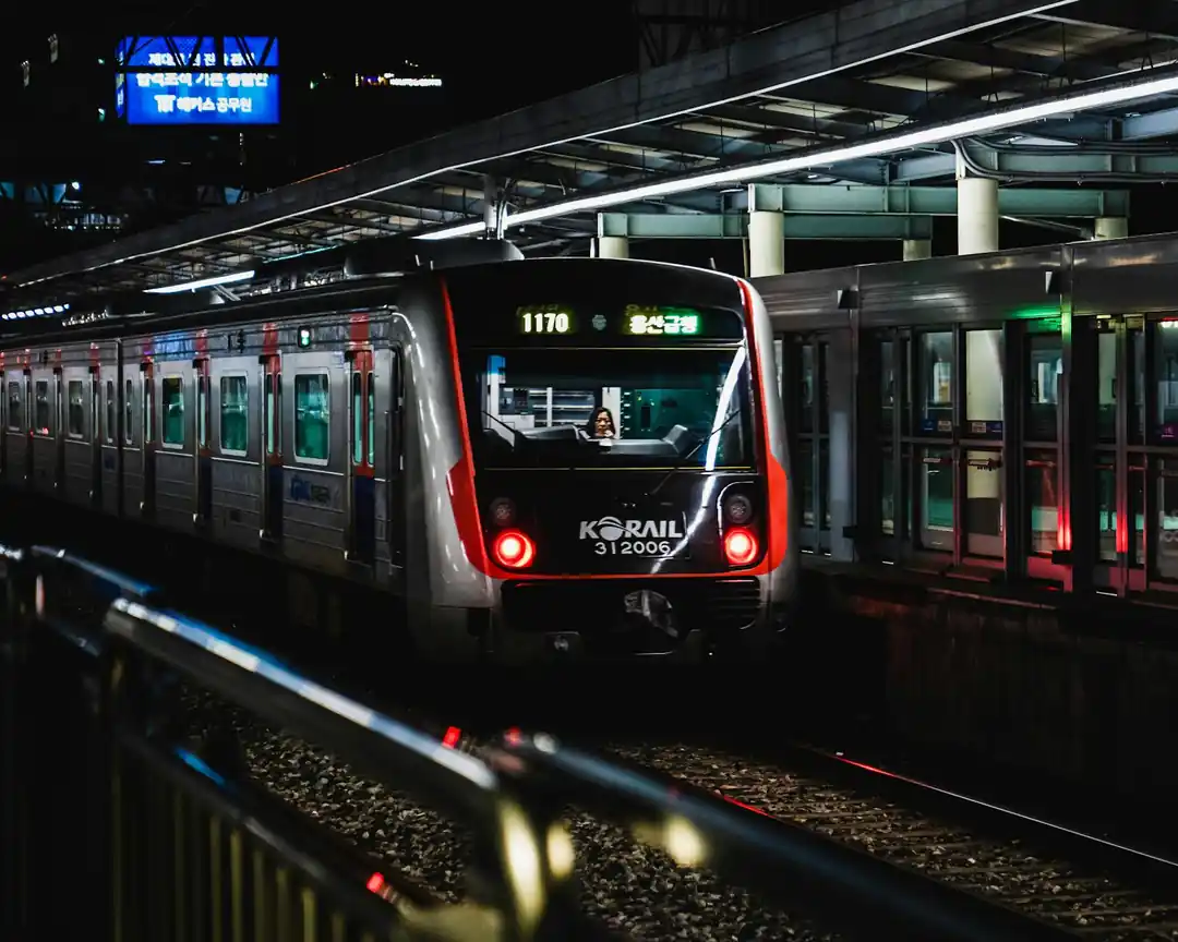 夜晚的首爾車站,一列Korail列車停靠在月台,周圍燈火通明,充滿都會感。
