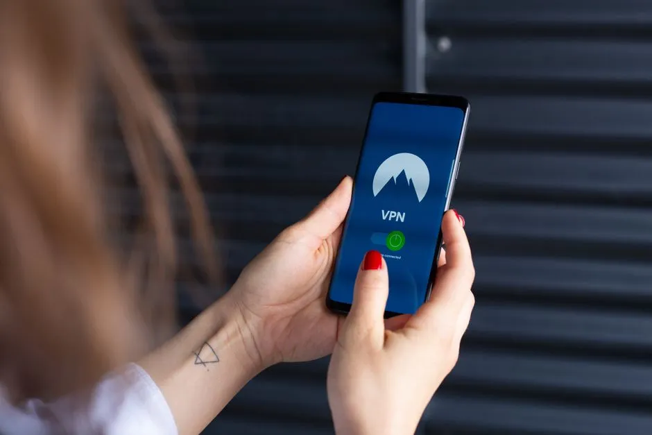 Hands holding a smartphone and interacting with a VPN application screen.