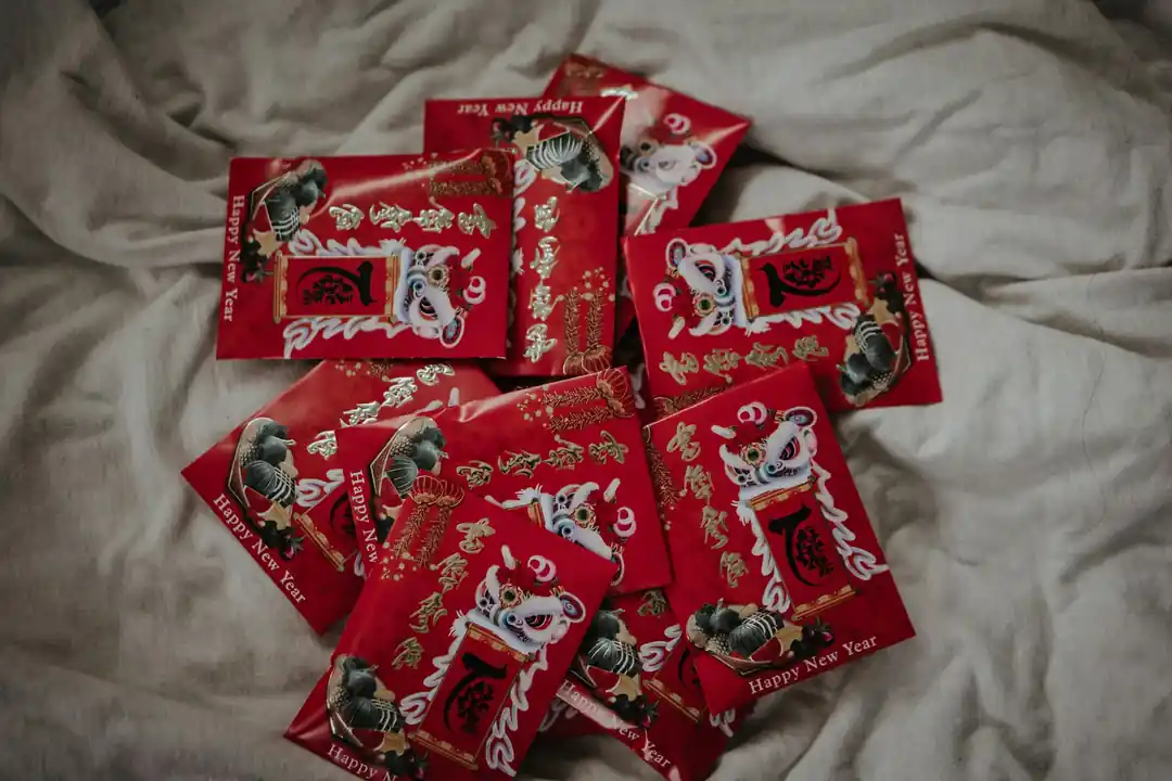 一堆充滿設計感的紅色紅包袋散落在柔軟的布上。