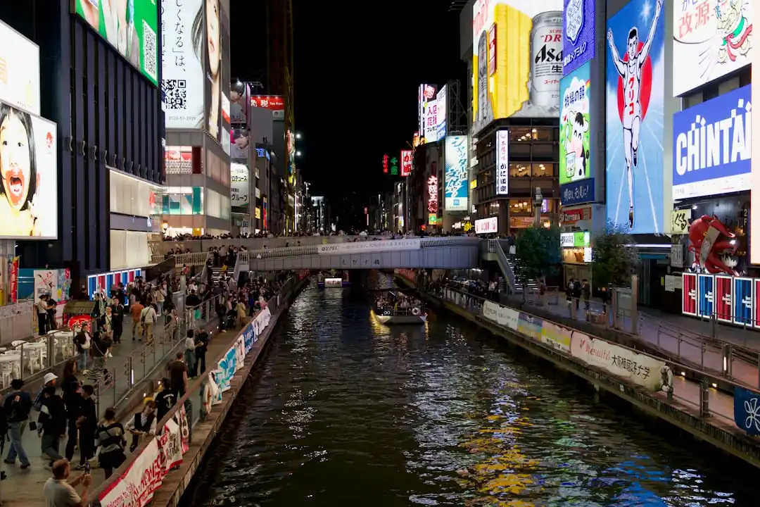 夜の道頓堀の活気ある街並みと川に映るネオン