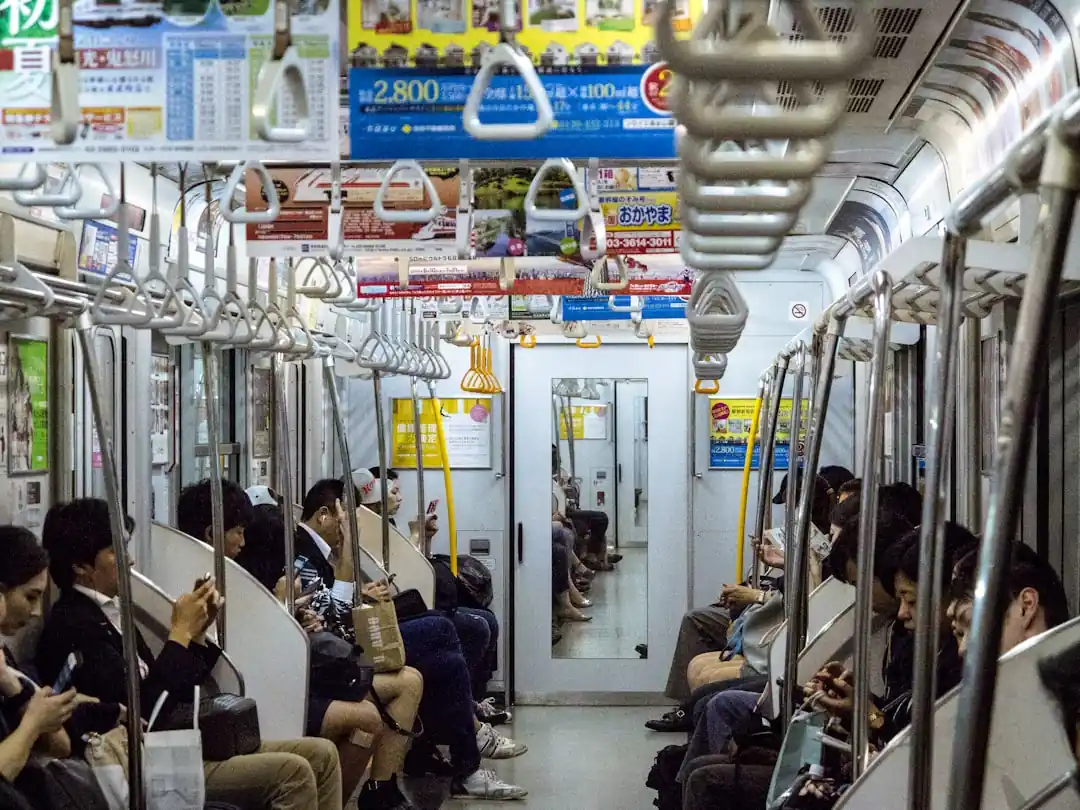 地下鉄の車内でスマートフォンを見つめる人々