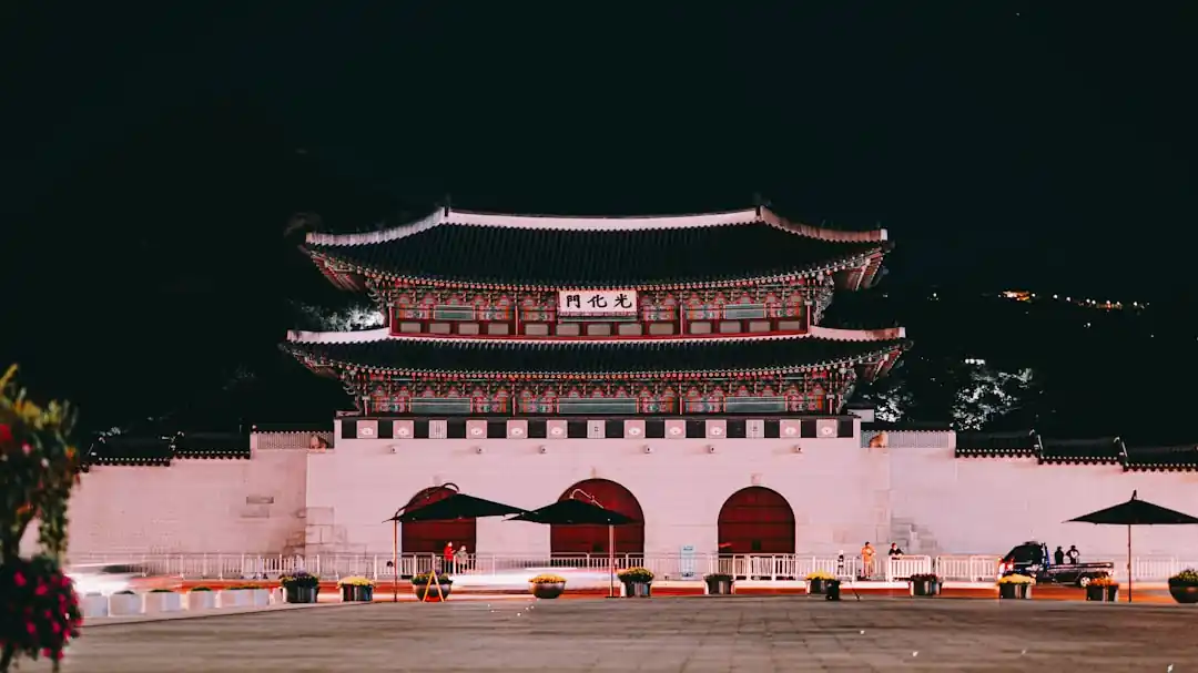 밤에 조명이 켜진 한국 전통 궁궐 문의 모습