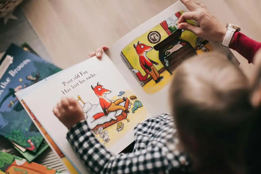 子供と大人が一緒に絵本を読んでいる様子