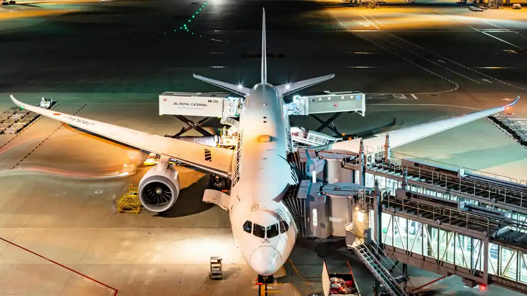 夜の空港で搭乗を待つ飛行機とターミナルの明かり