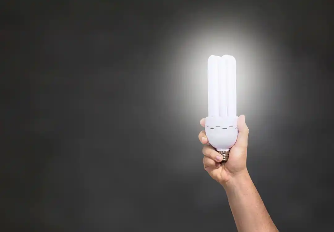 暗闇の中で優しく光る電球を手に持つ様子