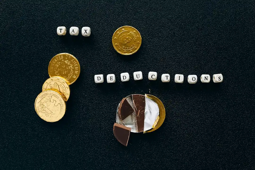 黒い背景に置かれたチョコレートコインと「TAX DEDUCTION」の文字