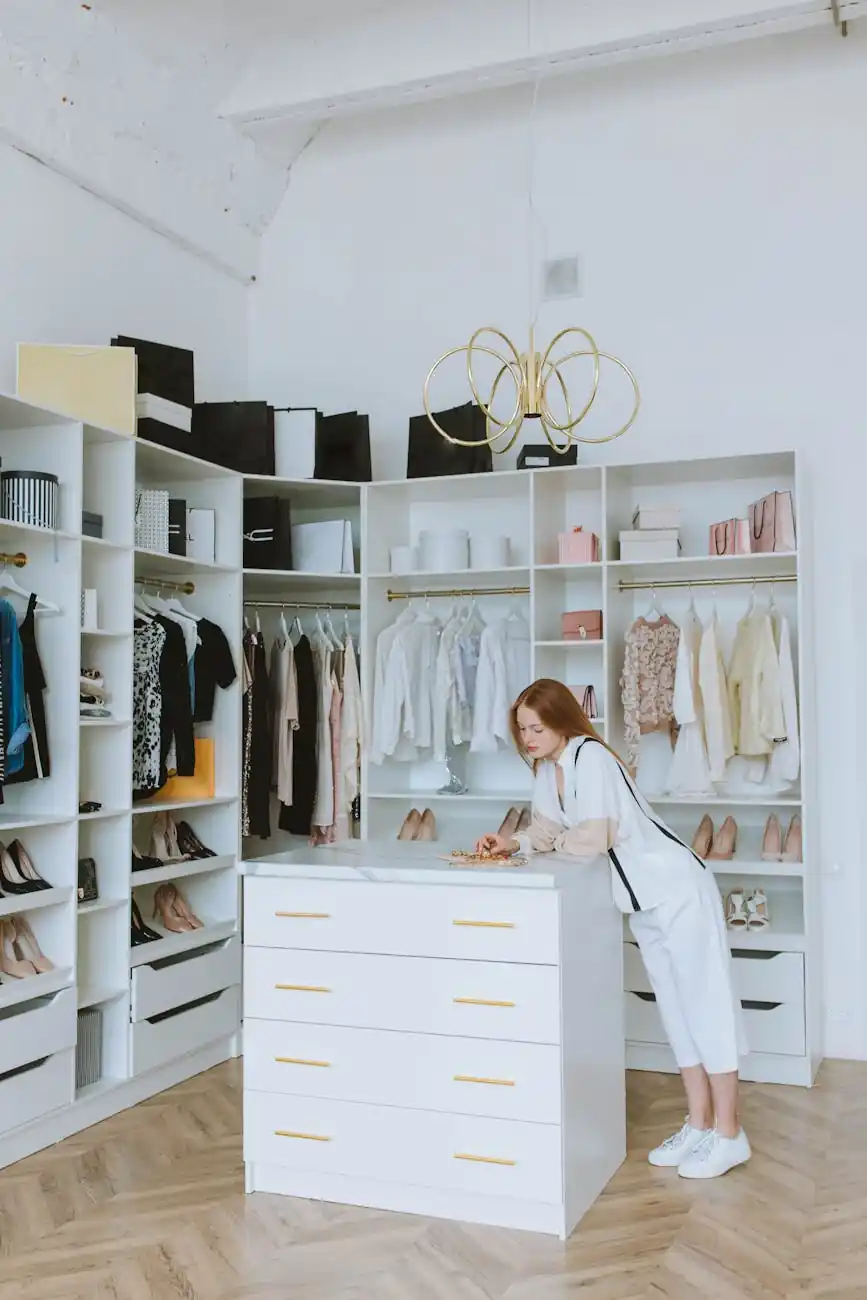 整然と衣類がかけられ、白いボックスで整理されたクローゼット。