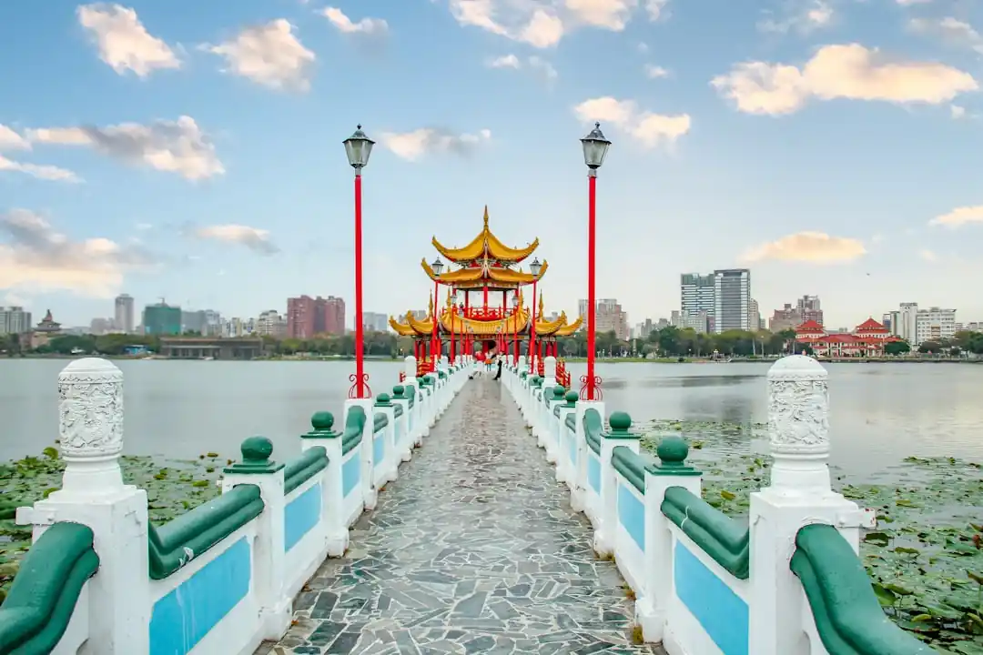 高雄蓮池潭的龍虎塔,在藍天白雲下與湖水相映,展現出傳統建築的宏偉氣勢。