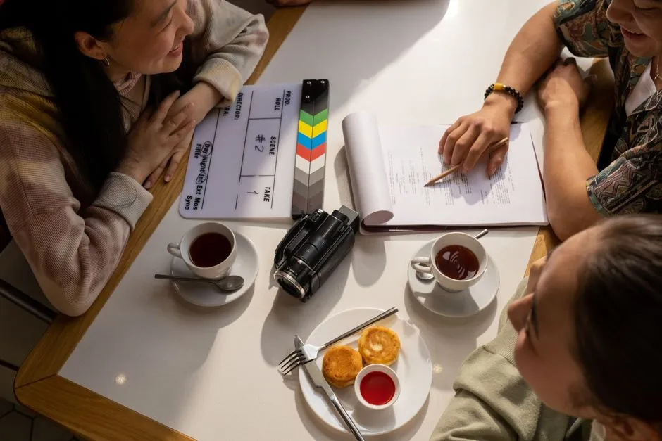 A film script, clapperboard, and camera on a table.