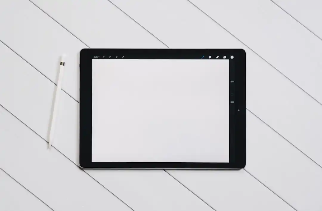 一台iPad Pro和Apple Pencil放在桌上,螢幕上顯示著Procreate繪圖軟體的介面。