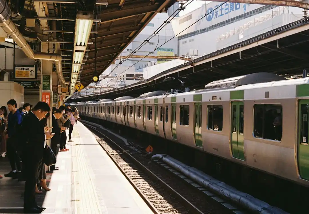 駅のホームで電車を待つ人々