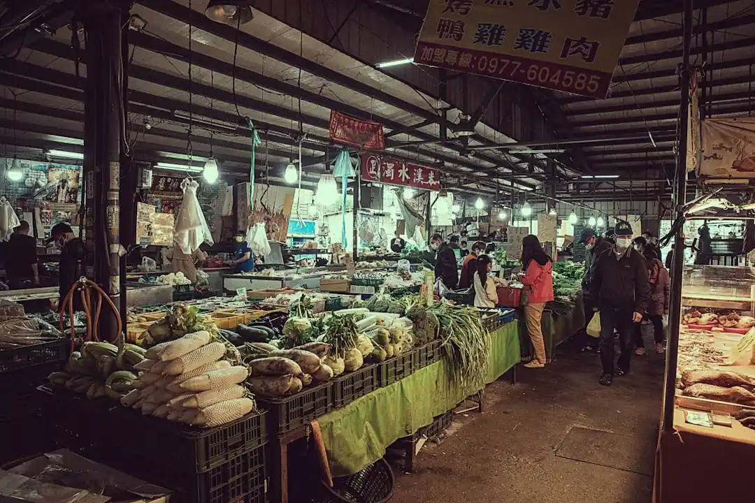 一群人圍繞在台灣的傳統市場攤位前。