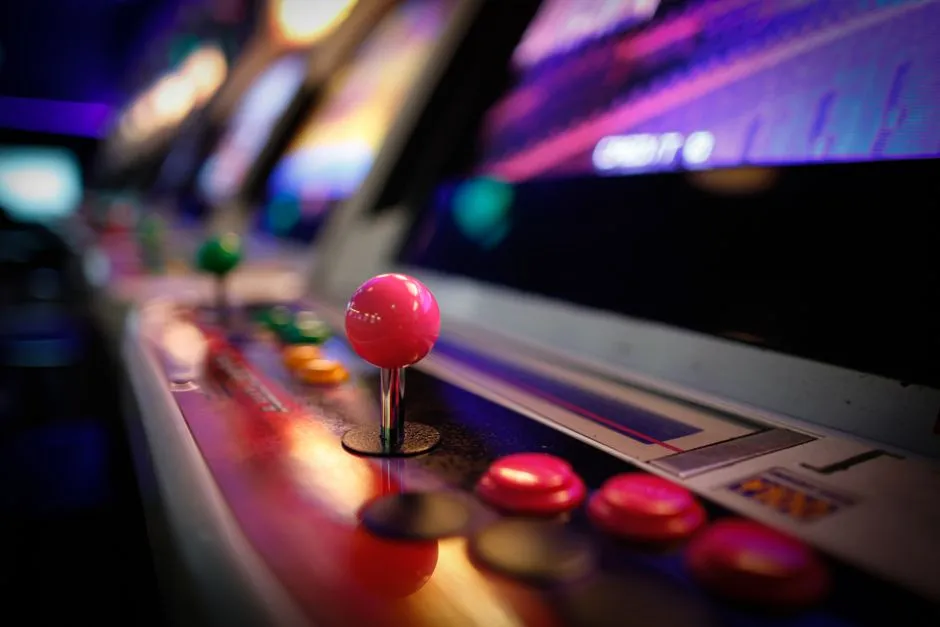 A close-up of colorful buttons and joysticks on a vintage arcade cabinet.