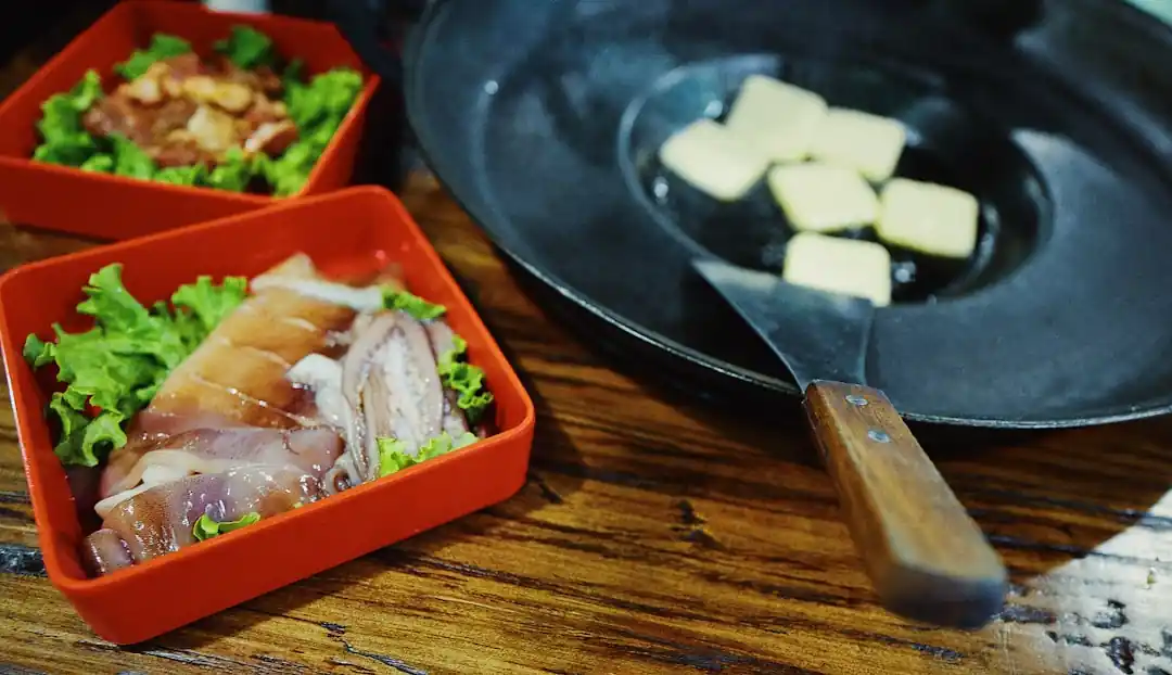 黒いフライパンで調理されている色とりどりの野菜と肉。