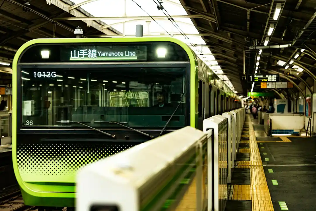 都会の交通を象徴する、東京の賑やかな駅で撮影された山手線の電車