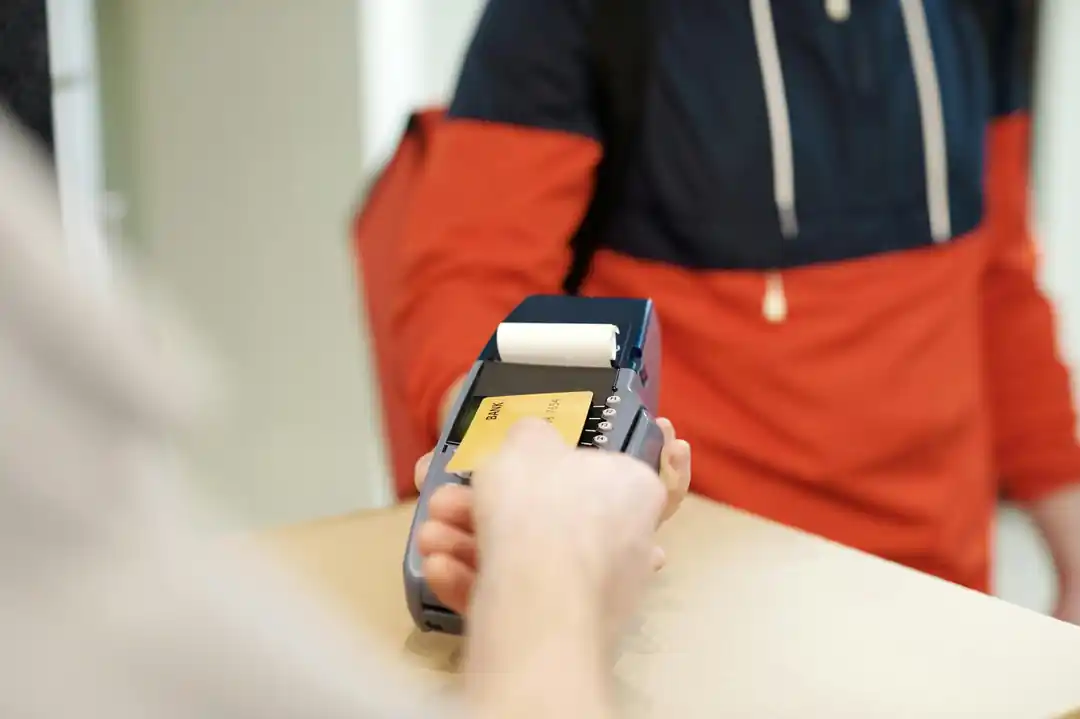 クレジットカード決済端末にカードをかざして、非接触で支払いをしている様子