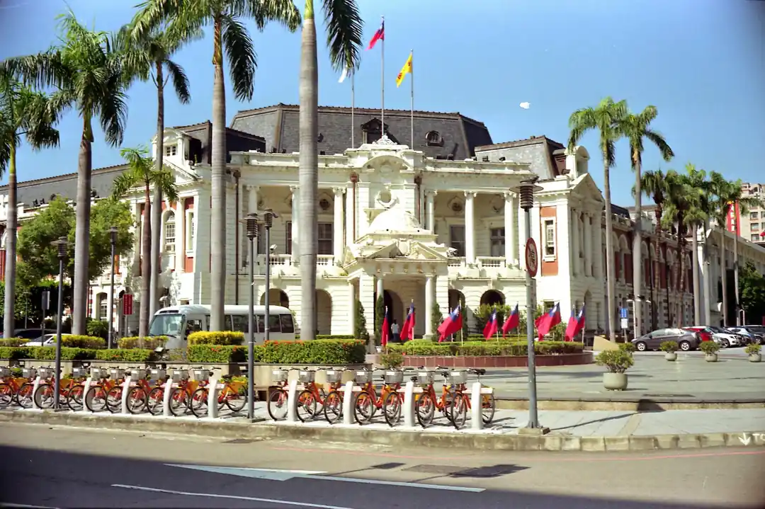 台中市政府周邊的公園綠地,有自行車和棕櫚樹,天氣晴朗。