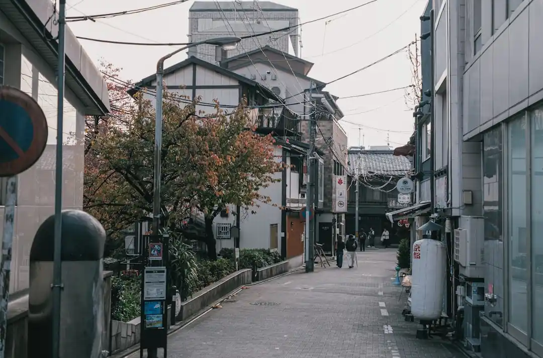 伝統的な日本の建物と木々が並ぶ細い路地