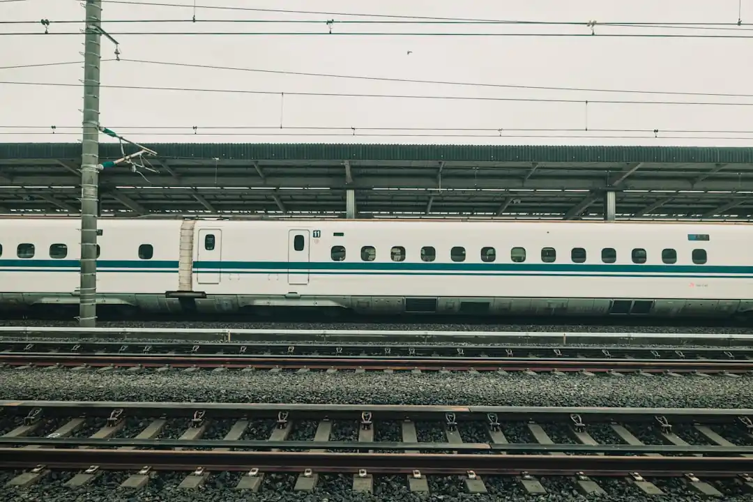 一列白色的子彈列車停靠在車站月台。