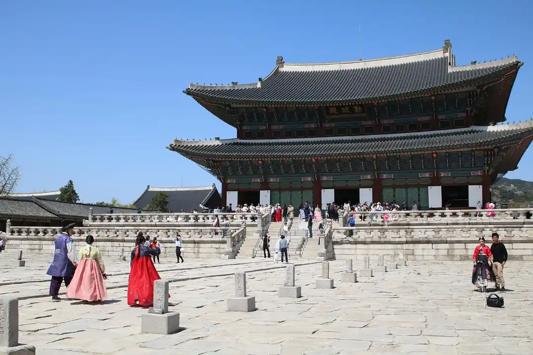 한복을 입은 사람들이 경복궁을 거닐고 있는 모습